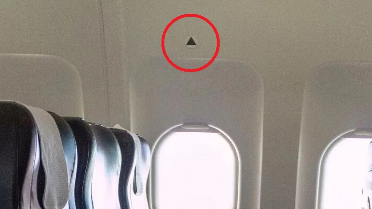 What does the small triangle above some airplane windows mean?